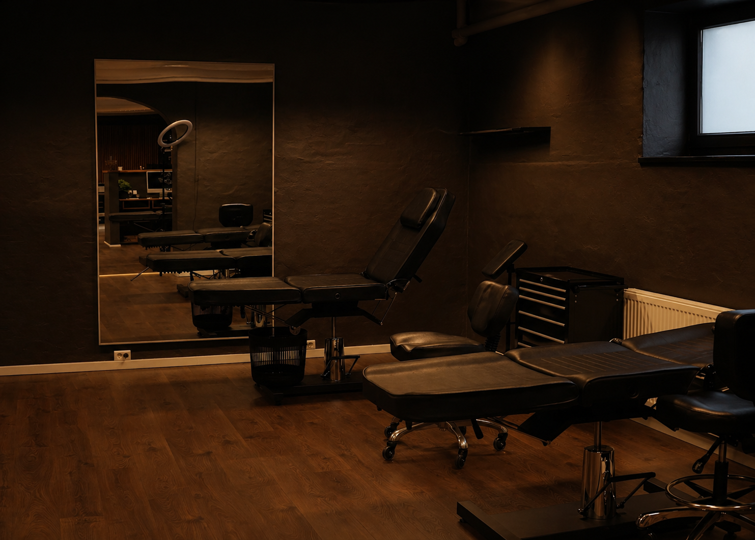 Stemning indefra tattoo-studiet i Esbjerg med arbejdsstationer og dæmpet belysning.